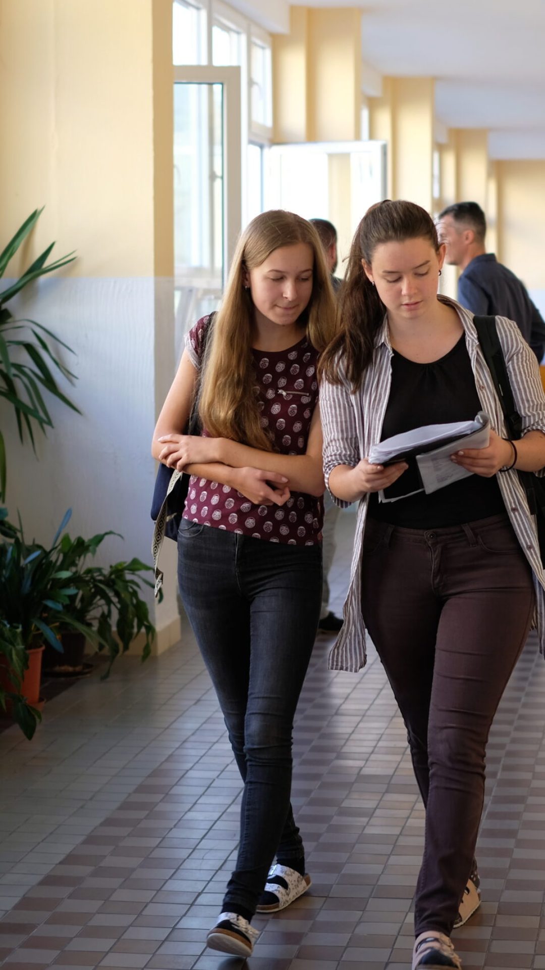 Dvě studentky se procházejí po chodbě v gymnáziu